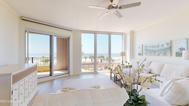 bedroom with crown molding, access to exterior, a water view, and light wood-type flooring