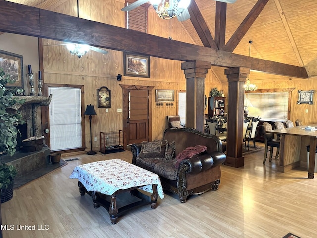 46 Stirling Rd, Natchez, MS 39120 - living room featuring ceiling fan, beamed ceiling, decorative columns, wooden walls, and light wood-type flooring