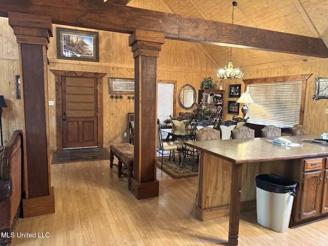 46 Stirling Rd, Natchez, MS 39120 - kitchen featuring wood walls, an inviting chandelier, hanging light fixtures, and decorative columns