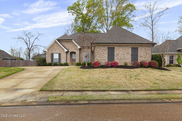 105 Federal Cv, Madison, MS 39110 - french country home featuring driveway, brick siding, fence, and a front lawn