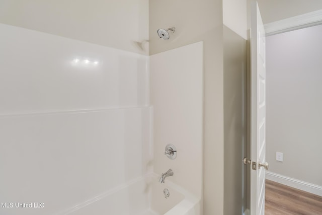 bathroom featuring wood-type flooring and tub / shower combination