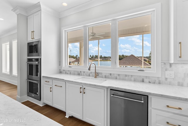 kitchen with white cabinetry, light stone counters, stainless steel appliances, and a healthy amount of sunlight