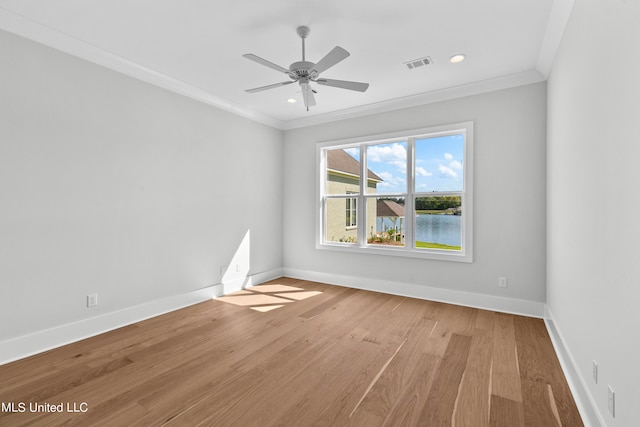 empty room featuring a water view, light hardwood / wood-style floors, crown molding, and ceiling fan