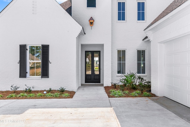 view of exterior entry featuring french doors and a garage