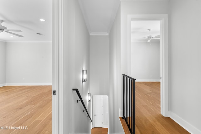 staircase featuring ornamental molding and hardwood / wood-style floors