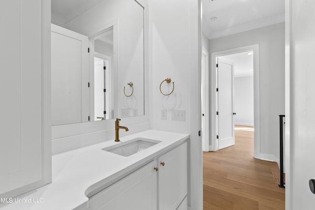 bathroom featuring vanity, crown molding, and hardwood / wood-style flooring