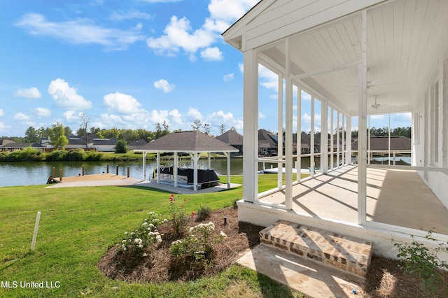 view of dock with a yard and a water view