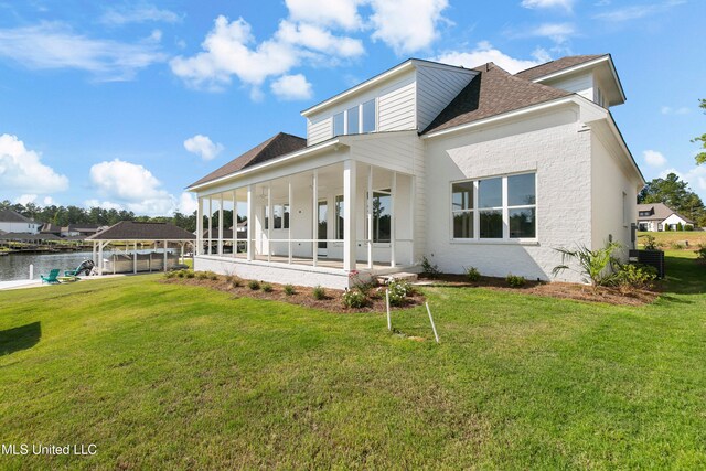 back of property with a yard and a water view