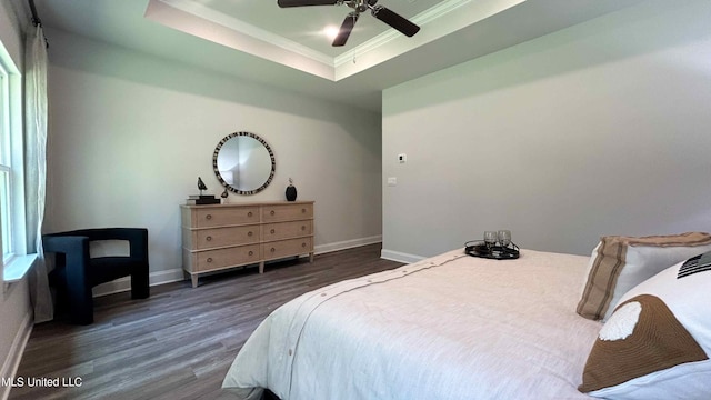 bedroom with dark hardwood / wood-style flooring, ornamental molding, a raised ceiling, and ceiling fan