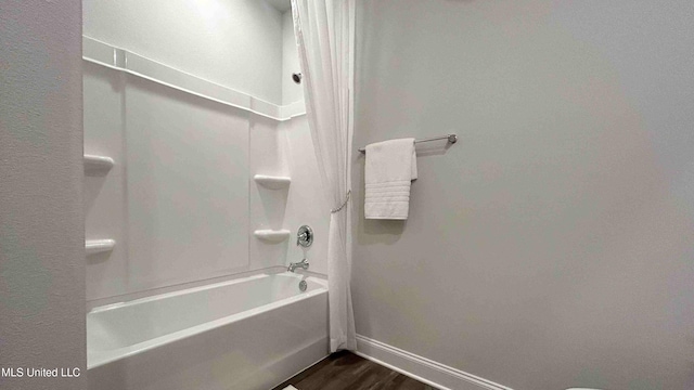 bathroom with hardwood / wood-style floors and shower / tub combo