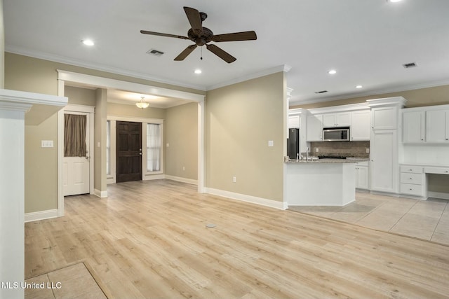 unfurnished living room with light wood-style flooring, visible vents, and baseboards