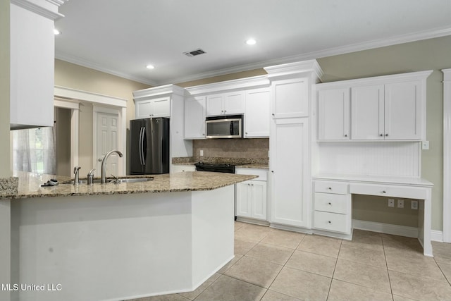 kitchen with a sink, visible vents, white cabinets, freestanding refrigerator, and stainless steel microwave