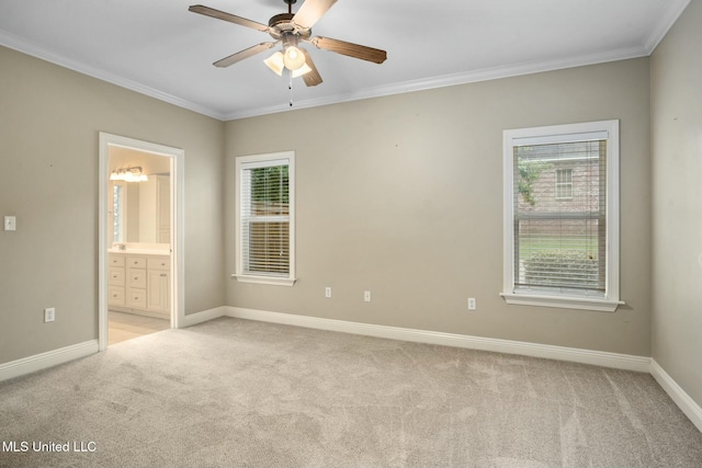 unfurnished bedroom featuring light carpet, multiple windows, baseboards, and crown molding