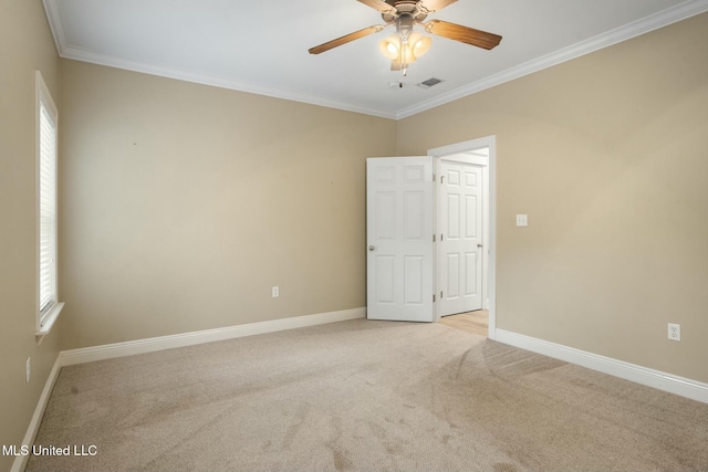 spare room featuring baseboards, visible vents, light colored carpet, and crown molding