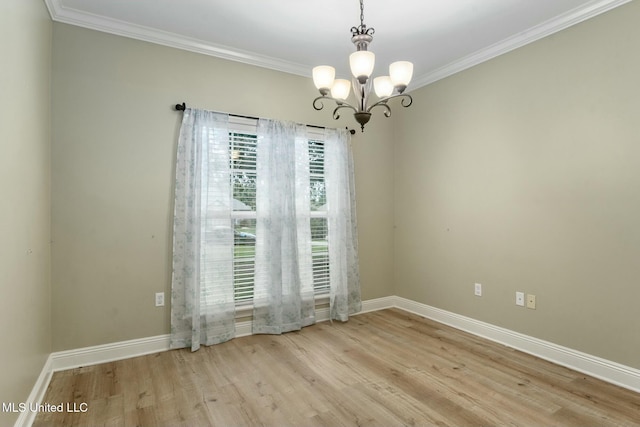 unfurnished room with a notable chandelier, ornamental molding, wood finished floors, and baseboards