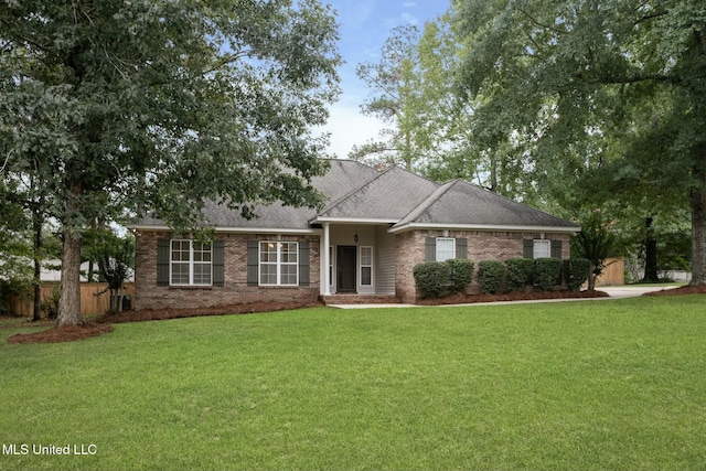 ranch-style home featuring roof with shingles, a front yard, fence, and brick siding