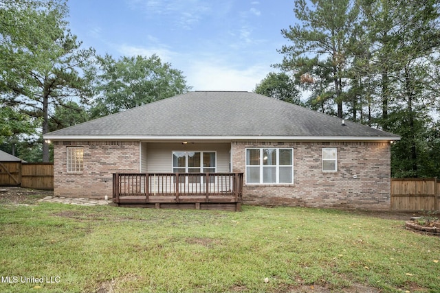 back of property featuring brick siding, a fenced backyard, a lawn, and a wooden deck