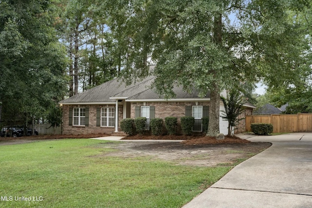 single story home with brick siding, fence, concrete driveway, roof with shingles, and a front yard