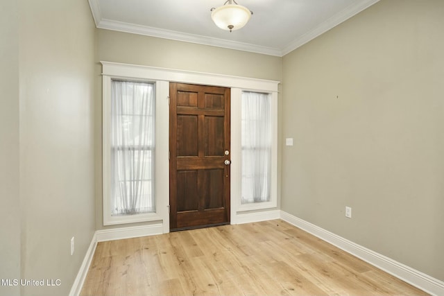 foyer featuring a healthy amount of sunlight, light wood-type flooring, baseboards, and crown molding