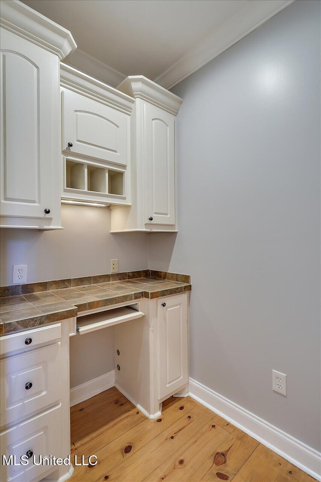 306 Canebreak Cv, Madison, MS 39110 - kitchen featuring light wood-type flooring, white cabinetry, dark countertops, crown molding, and baseboards