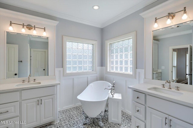 306 Canebreak Cv, Madison, MS 39110 - bathroom with wainscoting, two vanities, a freestanding bath, ornamental molding, and a decorative wall