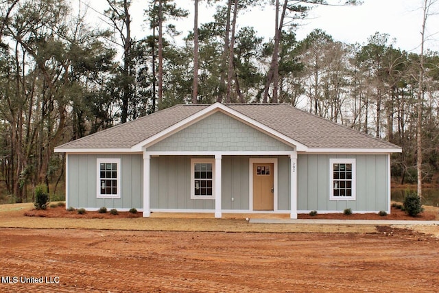 view of front of house with a porch, a shingled roof, and board and batten siding