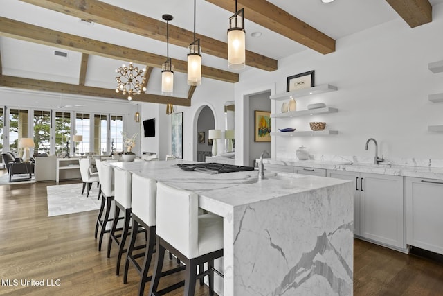 150 Old Trace Rd, Madison, MS 39110 - kitchen with light stone counters, arched walkways, beamed ceiling, dark wood finished floors, and stainless steel gas cooktop