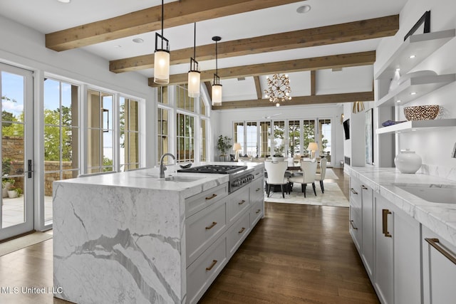 150 Old Trace Rd, Madison, MS 39110 - kitchen featuring beamed ceiling, decorative light fixtures, dark wood-style floors, light stone countertops, and a kitchen island with sink