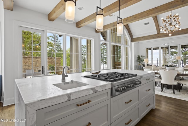 150 Old Trace Rd, Madison, MS 39110 - kitchen featuring stainless steel gas stovetop, beam ceiling, dark wood finished floors, light stone countertops, and decorative light fixtures