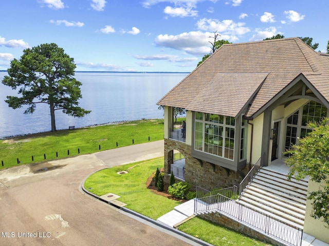 150 Old Trace Rd, Madison, MS 39110 - view of property exterior with a water view, stone siding, a lawn, and stucco siding