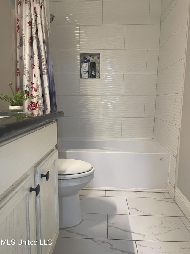 full bathroom featuring marble finish floor, shower / bath combo with shower curtain, vanity, and toilet