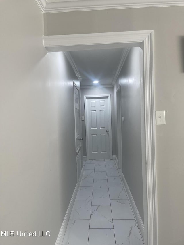 hallway with marble finish floor, baseboards, and crown molding