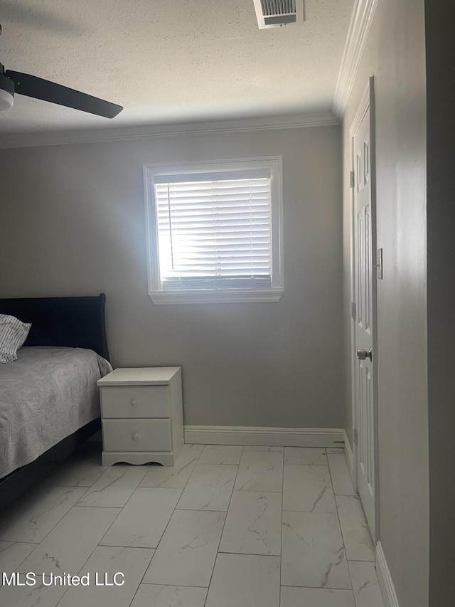 bedroom with marble finish floor, visible vents, ornamental molding, a textured ceiling, and baseboards