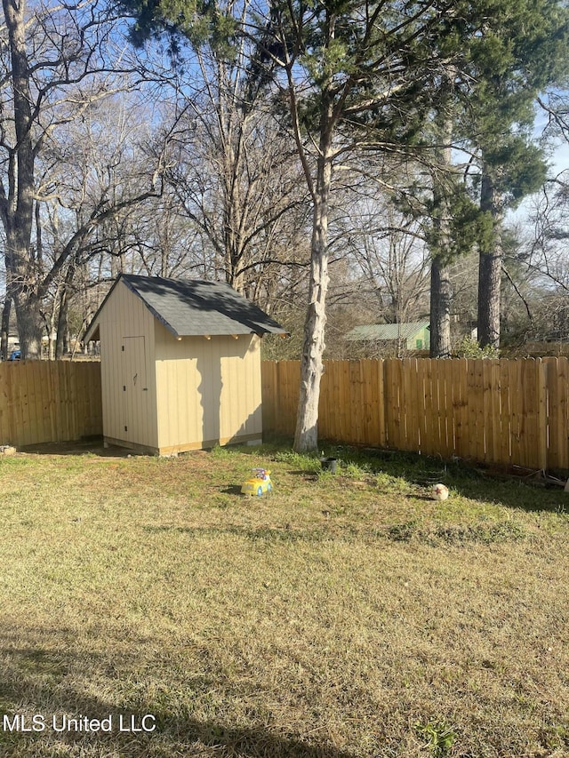 view of yard with a fenced backyard, an outdoor structure, and a storage unit