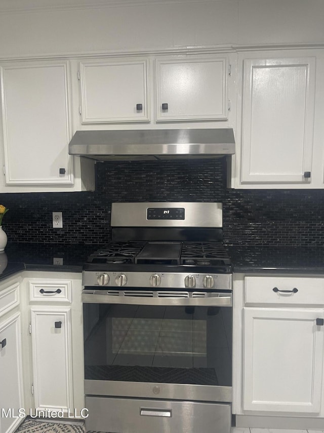 kitchen with ventilation hood, backsplash, stainless steel range with gas cooktop, and white cabinetry