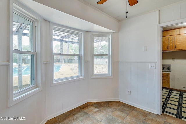 unfurnished dining area featuring crown molding and ceiling fan