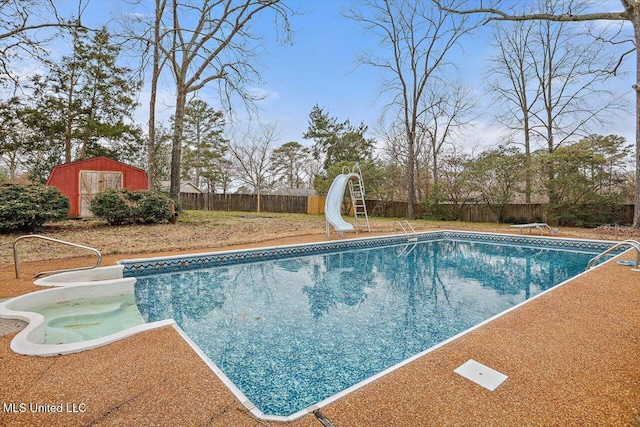 view of pool featuring a water slide, a diving board, and a storage unit