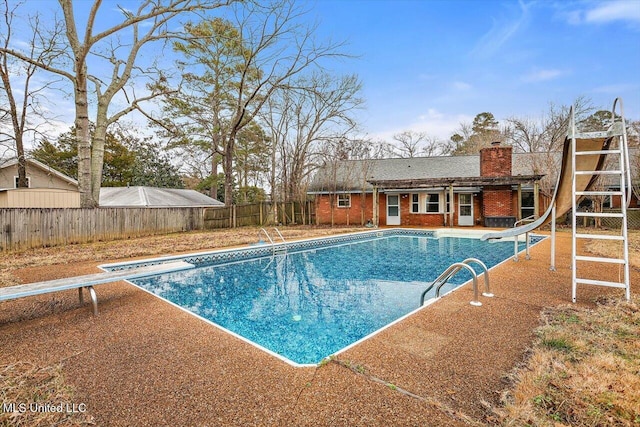 view of swimming pool featuring a diving board and a water slide