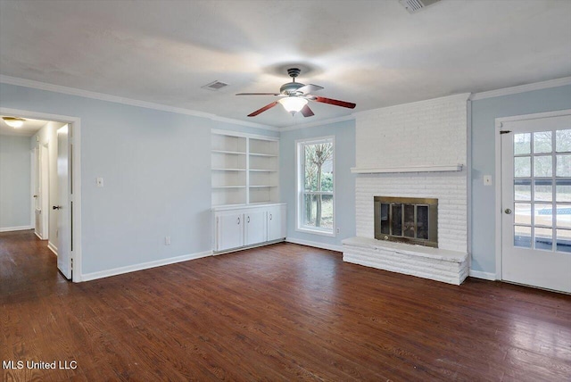 unfurnished living room featuring plenty of natural light, dark wood-type flooring, and a brick fireplace