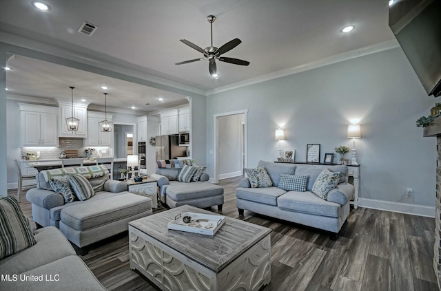 living room with baseboards, visible vents, dark wood-style flooring, ceiling fan, and crown molding