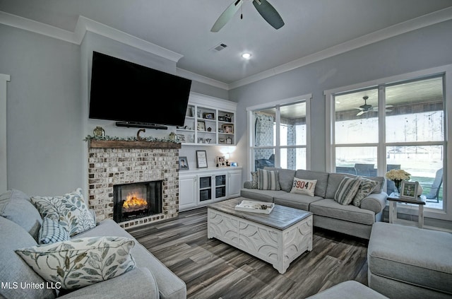 living room with dark wood finished floors, visible vents, crown molding, and a ceiling fan