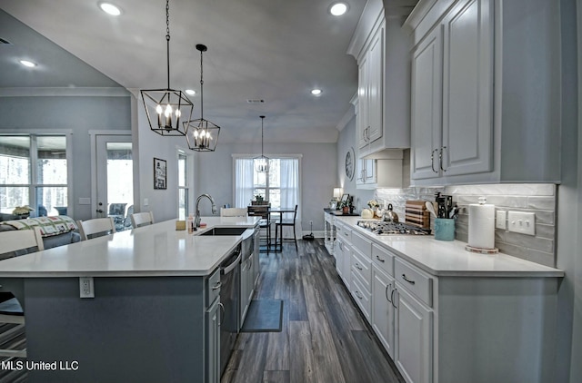 kitchen featuring a large island, ornamental molding, a sink, backsplash, and light countertops