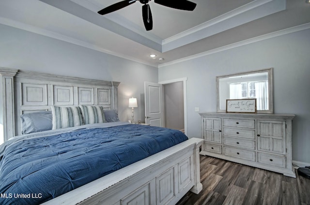 bedroom featuring dark wood finished floors, ceiling fan, a tray ceiling, and ornamental molding