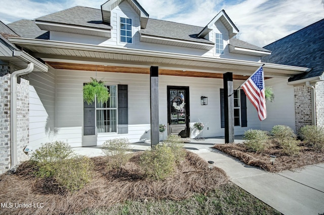 property entrance featuring covered porch and roof with shingles