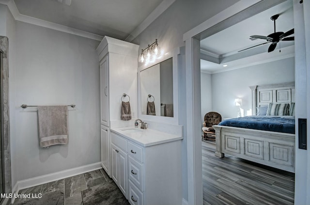 bathroom with ensuite bathroom, crown molding, baseboards, ceiling fan, and vanity