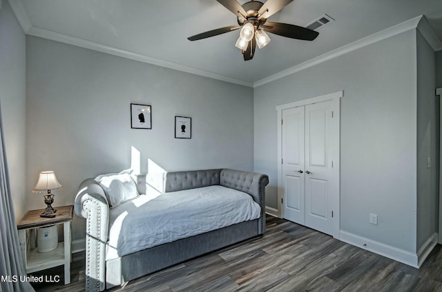 bedroom with baseboards, wood finished floors, visible vents, and ornamental molding