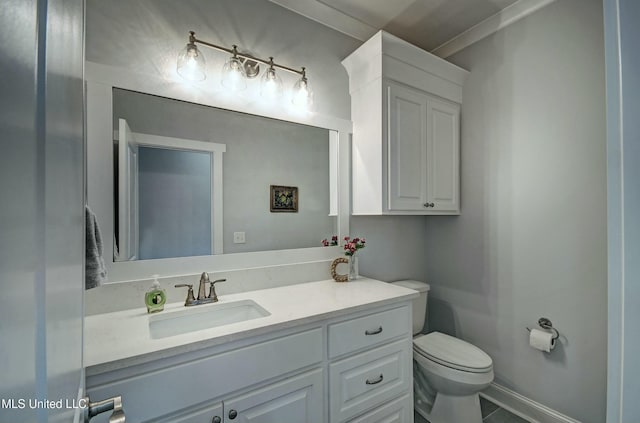 bathroom featuring toilet, vanity, and baseboards