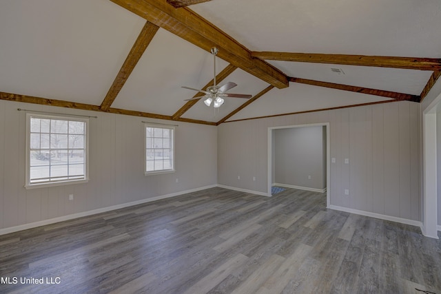 spare room featuring ceiling fan, lofted ceiling with beams, baseboards, and wood finished floors