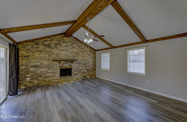 unfurnished living room featuring brick wall, ceiling fan, a fireplace, and wood finished floors