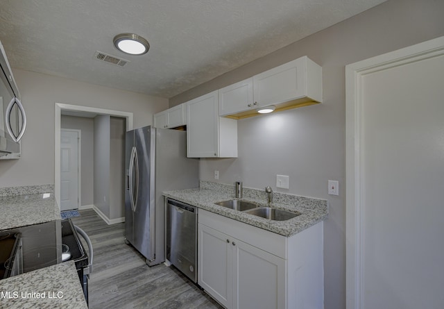 kitchen featuring a sink, visible vents, dishwasher, electric range, and light wood-style floors